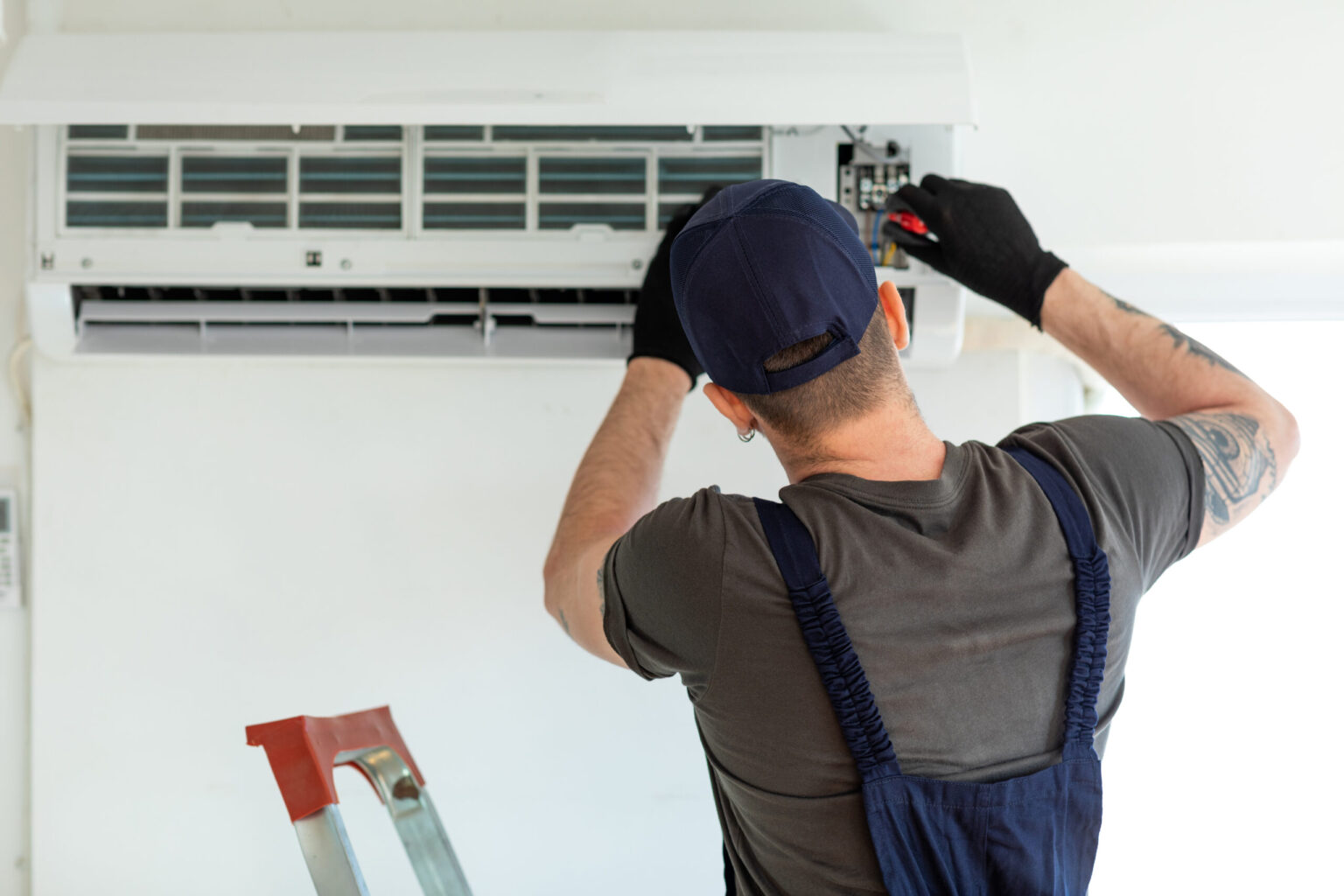 Stay Cool and Save Money with Timely Air Conditioning Repair Technician repairing air conditioner